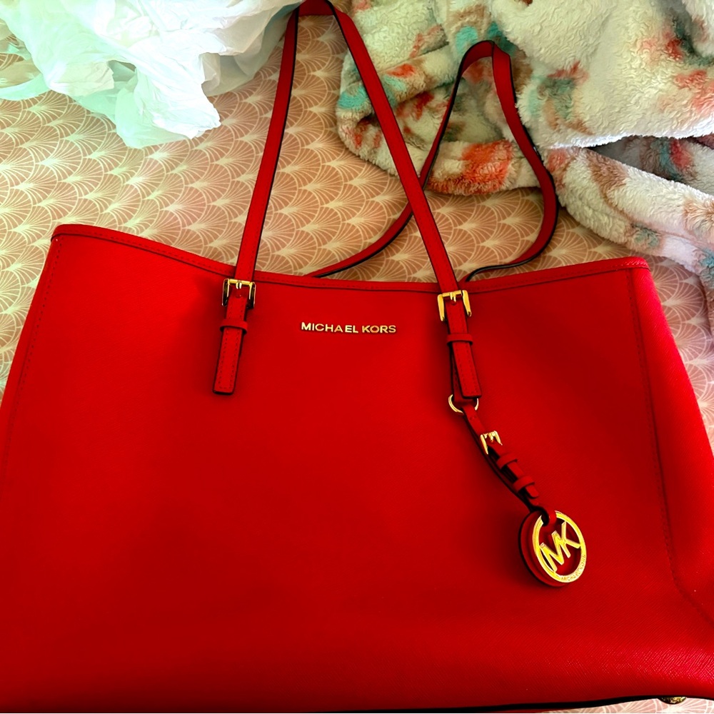 Medium, reddish orange Michael Kors hand bag.
